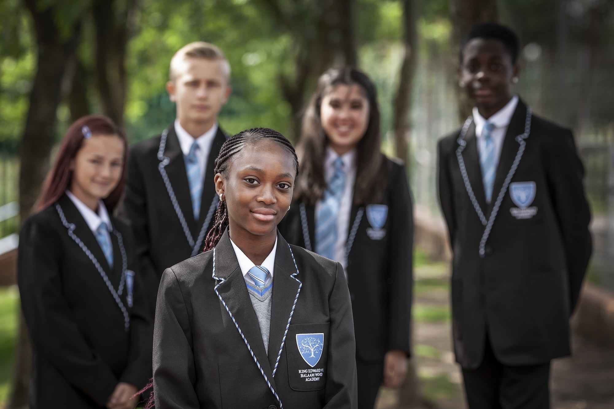 Students in King Edward VI Balaam Wood Academy uniforms smiling outdoors
